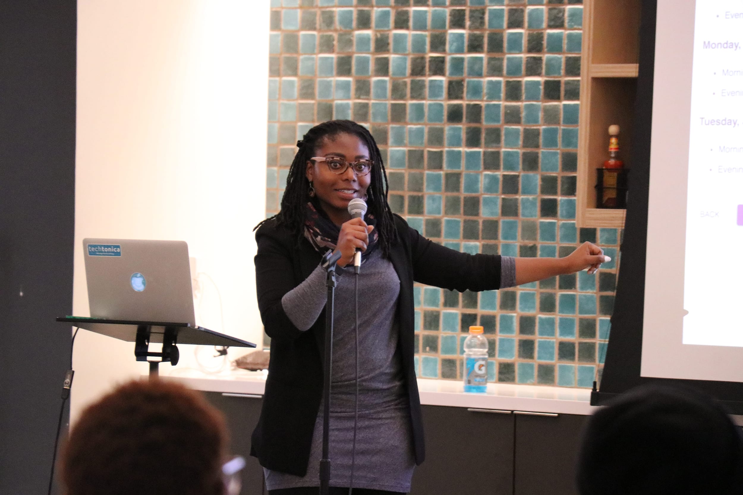Participant holding a microphone and gesturing to a project demo
